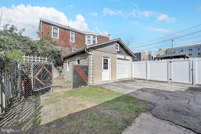 exterior space with a gate, fence, and driveway