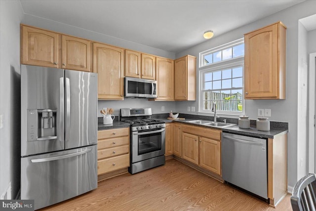 20973 Killawog Ter, Ashburn, VA 20147 - kitchen with appliances with stainless steel finishes, a sink, dark countertops, light brown cabinetry, and light wood-style floors