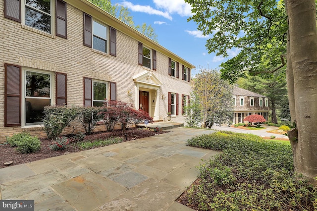 colonial home featuring brick siding
