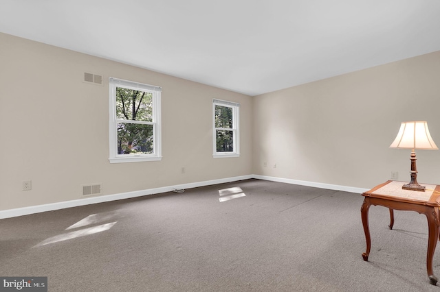 unfurnished room featuring baseboards, carpet floors, and visible vents