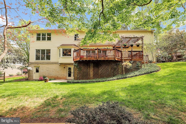 back of house with brick siding, a wooden deck, and a yard