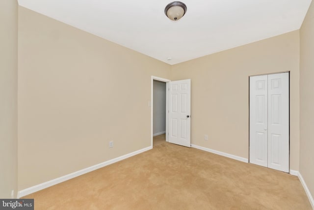 2828 Woodbrook Ave, Baltimore, MD 21217 - unfurnished bedroom featuring a closet, baseboards, and light carpet