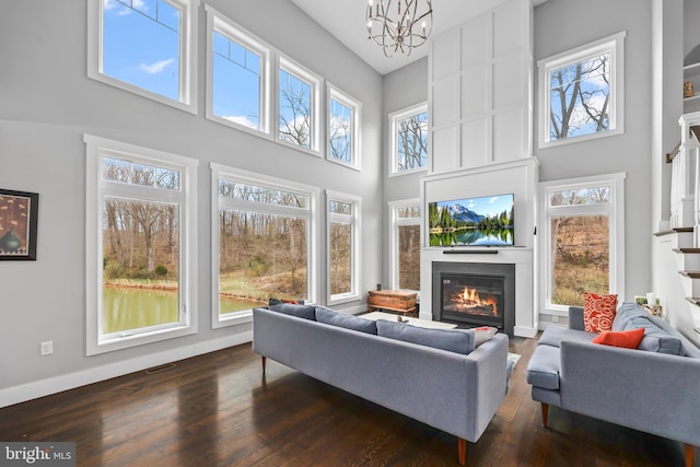 59 N Ridgemont Way, Shepherdstown, WV 25443 - living area with a glass covered fireplace, a high ceiling, dark wood-type flooring, and a chandelier