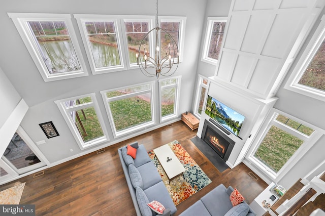 59 N Ridgemont Way, Shepherdstown, WV 25443 - living area with a high ceiling, a fireplace with flush hearth, a chandelier, and dark wood-style flooring