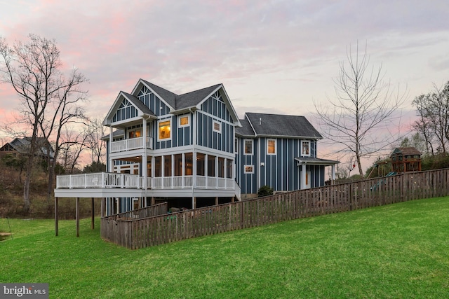 59 N Ridgemont Way, Shepherdstown, WV 25443 - back of house at dusk featuring board and batten siding, a balcony, a playground, a deck, and a sunroom