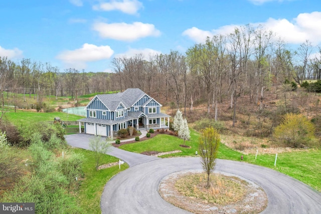 59 N Ridgemont Way, Shepherdstown, WV 25443 - view of front of home with curved driveway, a garage, a front lawn, a forest view, and a porch