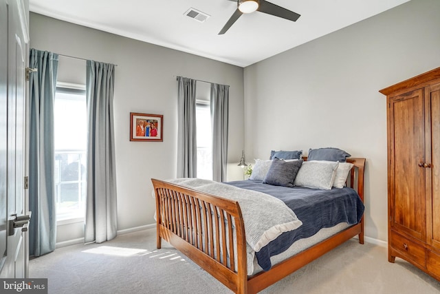 bedroom featuring light colored carpet, baseboards, ceiling fan, and visible vents