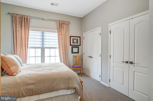 bedroom with carpet floors, baseboards, and visible vents