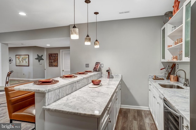 kitchen featuring wine cooler, a sink, open shelves, a peninsula, and dark wood-type flooring