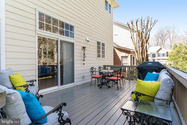 deck with outdoor dining area and a grill