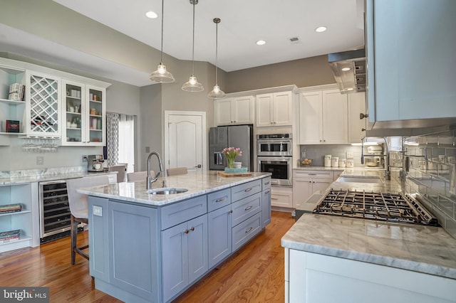 kitchen with appliances with stainless steel finishes, open shelves, wine cooler, a sink, and white cabinetry