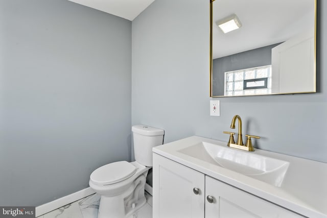 bathroom featuring baseboards, marble finish floor, toilet, and vanity