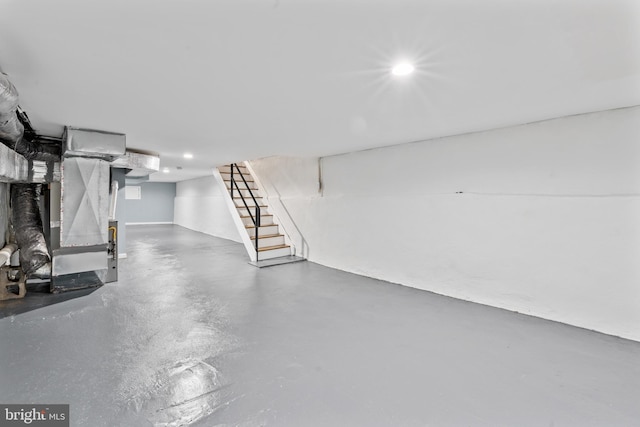 basement featuring heating unit, stairs, and recessed lighting