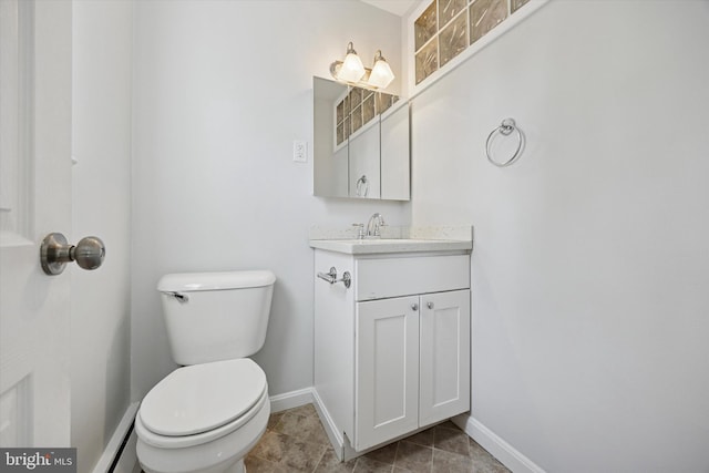 bathroom with toilet, baseboards, and vanity