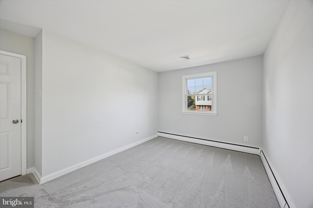 carpeted spare room with a baseboard heating unit, baseboards, visible vents, and baseboard heating
