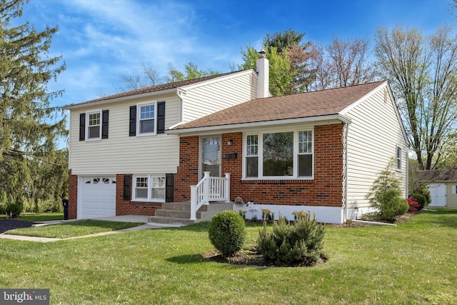 split level home featuring a garage, a chimney, a front lawn, and brick siding