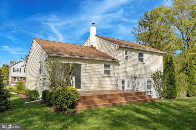 back of property featuring a lawn, a wooden deck, and a chimney