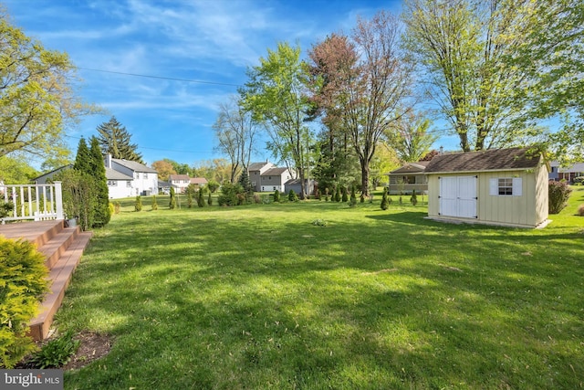 view of yard with a storage shed, fence, and an outdoor structure