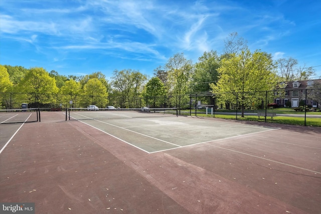 view of tennis court featuring community basketball court and fence