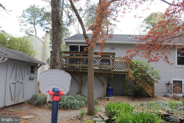 rear view of house featuring a storage unit, a deck, an outdoor structure, and stairs