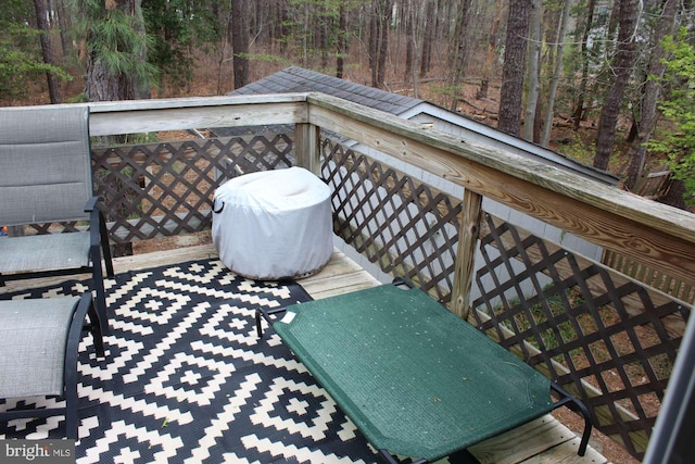 wooden deck featuring a view of trees and area for grilling