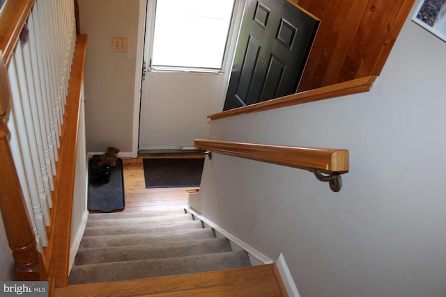 staircase with baseboards and wood finished floors