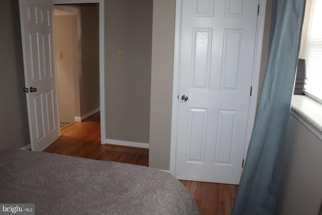 bedroom with baseboards and wood finished floors