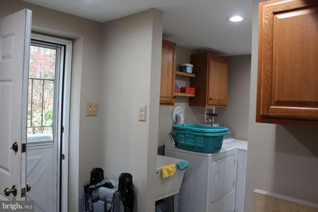 washroom featuring recessed lighting, washer and dryer, and cabinet space