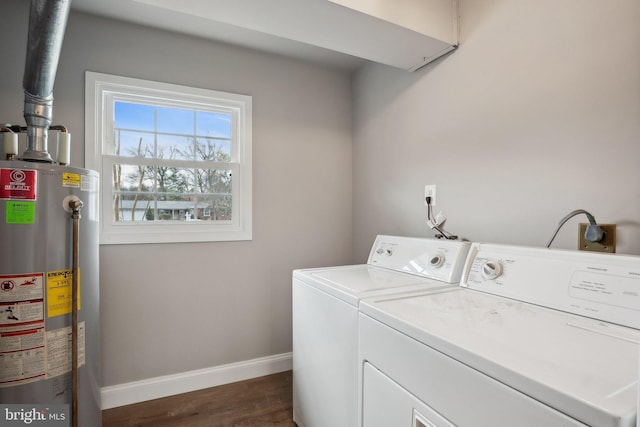 laundry room with water heater, dark wood-type flooring, baseboards, washing machine and dryer, and laundry area