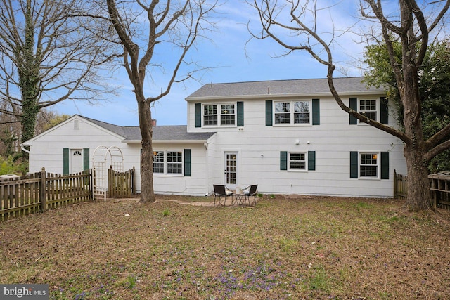 rear view of property with fence and a yard