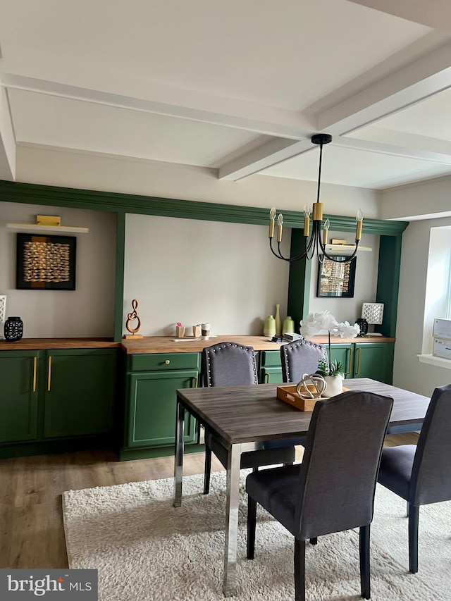 dining area with an inviting chandelier, beam ceiling, and light wood-type flooring