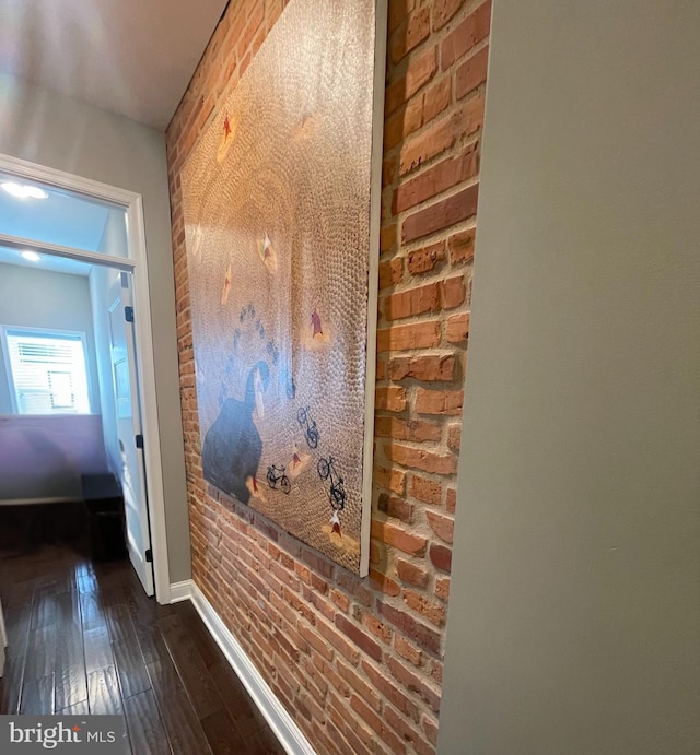 713 S Decker Ave, Baltimore, MD 21224 - hall with dark wood-style floors, brick wall, and baseboards