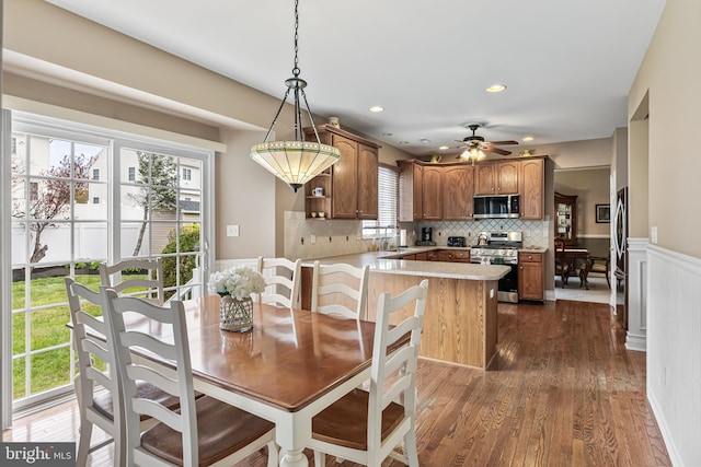 dining area with wainscoting, ceiling fan, dark wood finished floors, and recessed lighting