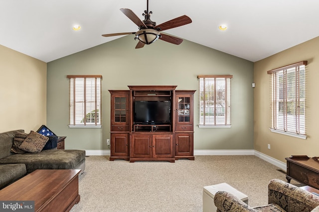 living room featuring plenty of natural light, light colored carpet, baseboards, and a ceiling fan