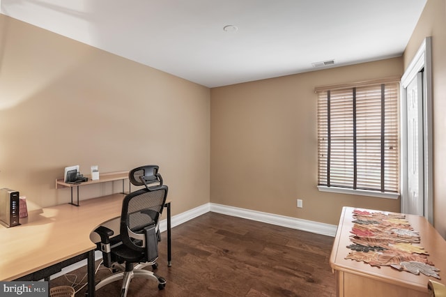 office space with dark wood-type flooring, baseboards, and visible vents
