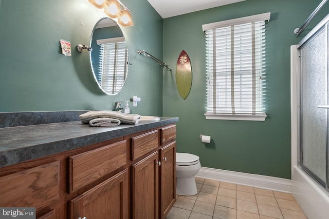full bathroom with toilet, baseboards, tile patterned flooring, and a wealth of natural light