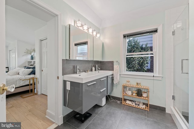 ensuite bathroom featuring tasteful backsplash, ensuite bath, a healthy amount of sunlight, and a shower stall
