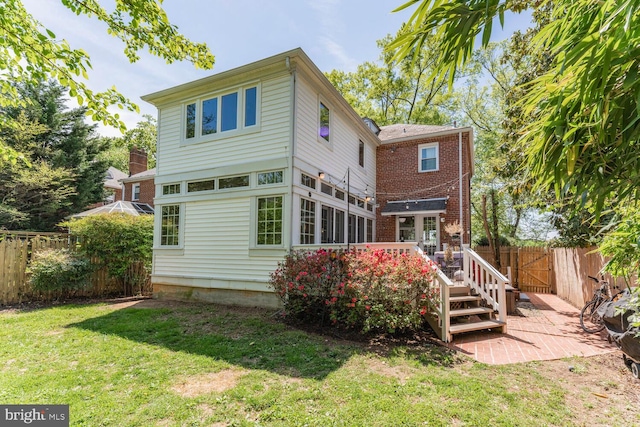 back of property featuring a lawn, a deck, a patio, and a fenced backyard