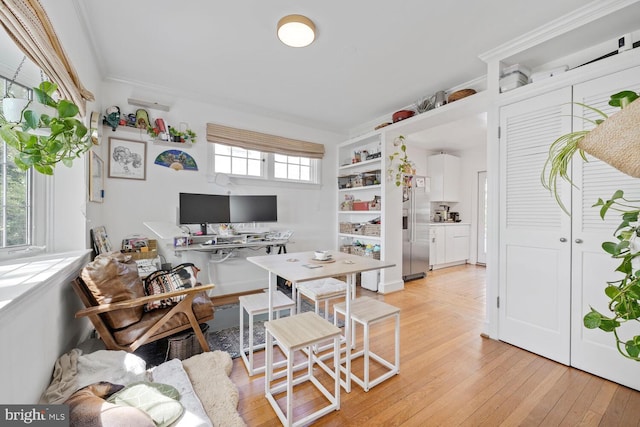 home office with light wood-type flooring and crown molding