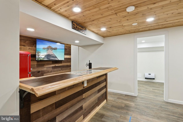 bar area with recessed lighting, wooden ceiling, wood finished floors, wooden walls, and baseboards