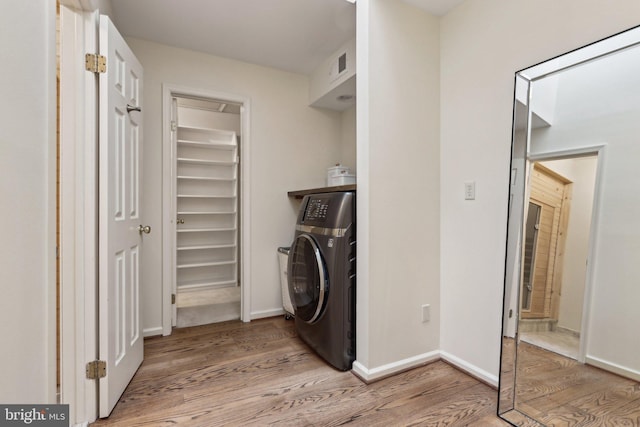 washroom with washer / dryer, light wood-type flooring, and baseboards