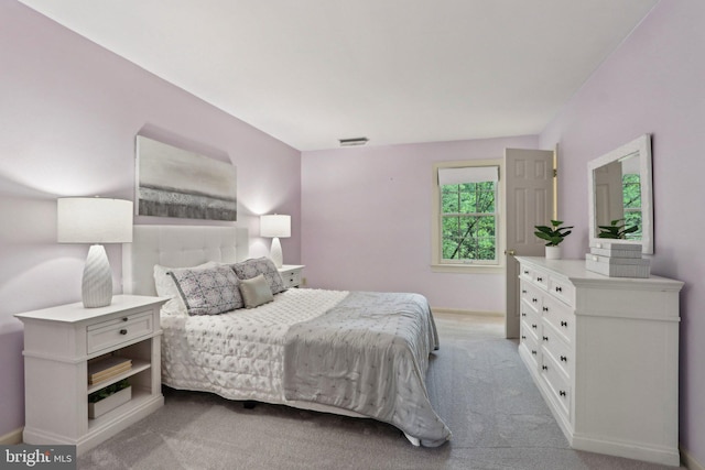 bedroom featuring light carpet and baseboards