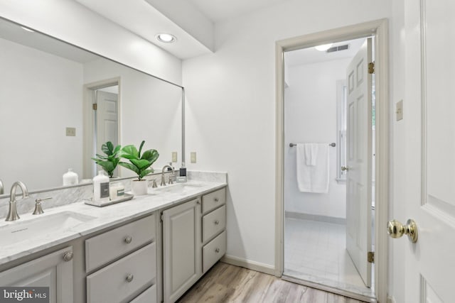 full bath featuring double vanity and wood finished floors
