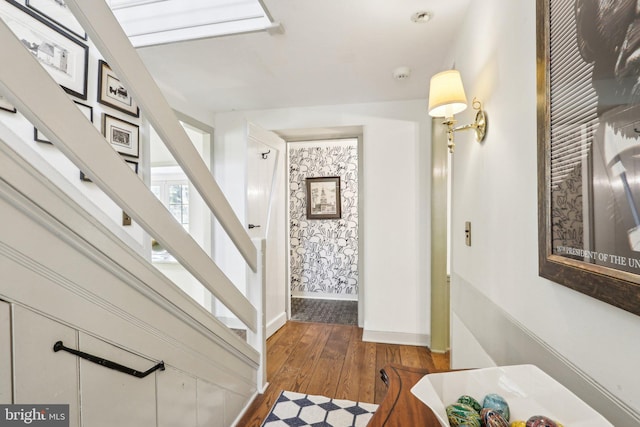 foyer entrance with stairs, wood finished floors, and baseboards