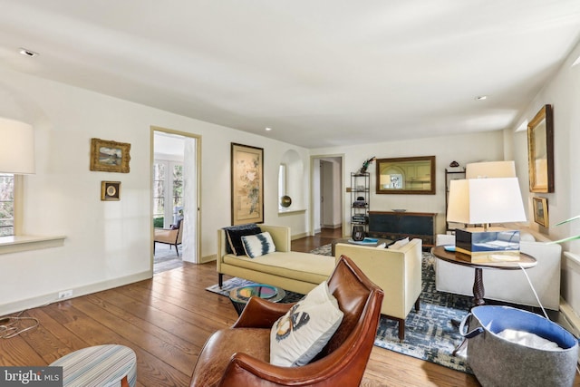 living area with plenty of natural light, hardwood / wood-style floors, and baseboards