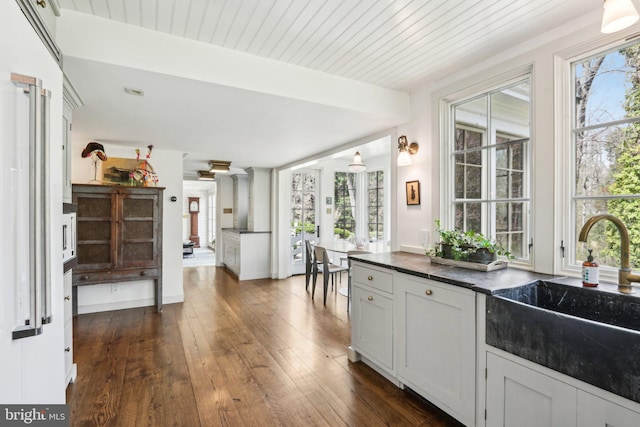 kitchen featuring a sink, dark countertops, and plenty of natural light