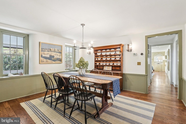 dining area featuring wood-type flooring, a chandelier, and healthy amount of natural light