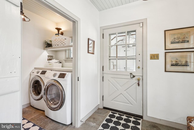 clothes washing area featuring washing machine and clothes dryer and baseboards