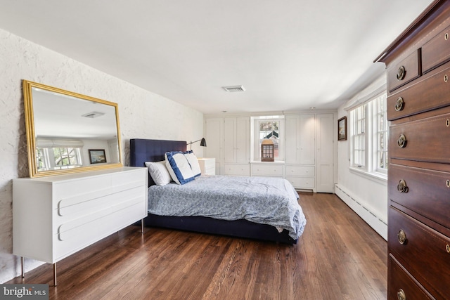bedroom featuring baseboard heating and dark wood-type flooring
