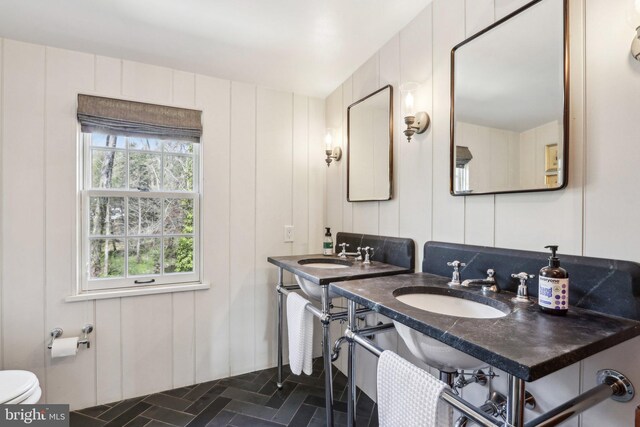 bathroom with a decorative wall and toilet